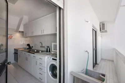 a kitchen with a washing machine and a sink at City Center Albufeira in Albufeira