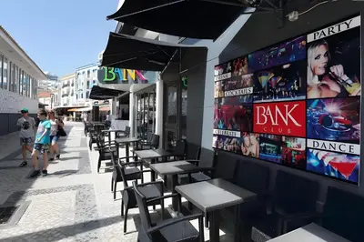 a row of tables and chairs outside of a restaurant at City Center Albufeira in Albufeira