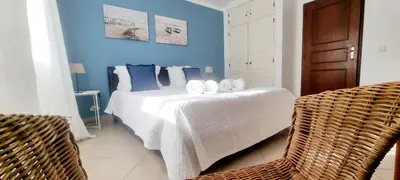 a bedroom with a white bed with blue walls at Casa Dos Cedros in Guia
