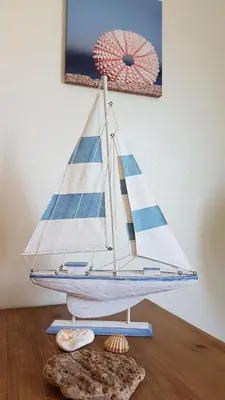 a toy sailboat on a table with shells on the floor at Casa Dos Cedros in Guia