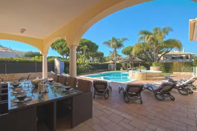 a large swimming pool in front of a house at Villa Hera in Vilamoura