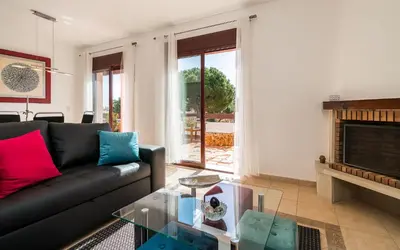 a living room with a couch and a fireplace at Vilasol apartment by Intiholidays in Vilamoura