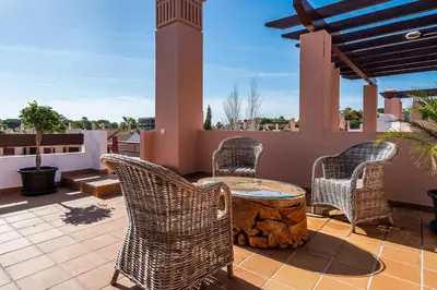 a patio with wicker chairs and a table on a roof at Vilasol apartment by Intiholidays in Vilamoura