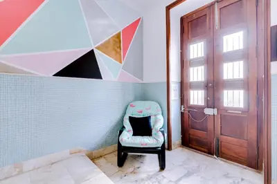 a chair in a room with a door at À da Avó -The Guesthouse in Faro