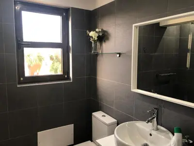 a bathroom with a sink and a toilet and a window at Vilamoura 2 bed new apartment in Vilamoura