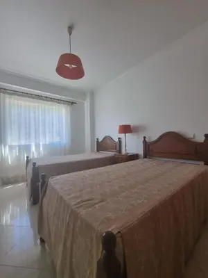 a bedroom with two beds and a large window at Albufeira Apart. T2 Baixa in Albufeira