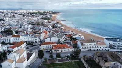 a white building with a door in a street at Olimar Sea View Apartment in Albufeira