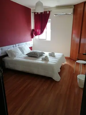 a bedroom with a white bed with a red wall at Guesthouse RSA by Umbral in Almancil