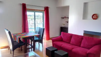 a living room with a red couch and a table at Albufeira Marina Penthouse 1 in Albufeira