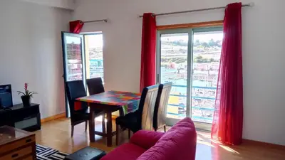 a living room with a table and a window at Albufeira Marina Penthouse 1 in Albufeira