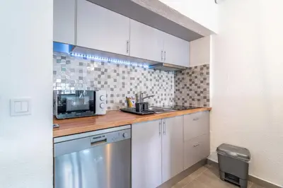 a small kitchen with white cabinets and a microwave at Villa Magna - Apt- 206 by HelloVacations in Albufeira