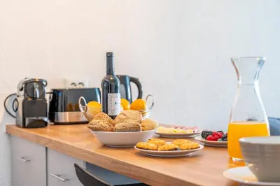 a table with plates of food and a bottle of wine at Villa Magna - Apt- 206 by HelloVacations in Albufeira