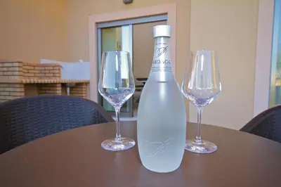 a bottle of wine and two wine glasses on a table at Pinheiros da Balaia Villas in Albufeira