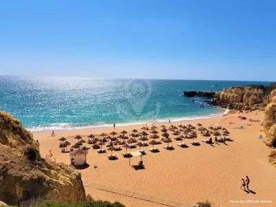 a beach with umbrellas and people on the beach at Apt T2 Jardins do Castelo - Albufeira, Algarve in Albufeira