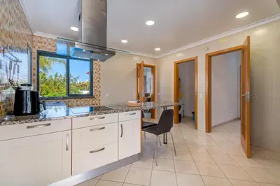 a kitchen with white cabinets and a sink and a window at Villa Ruana - 5 bedrooms on Suite- Free out door Hot Jacuzzi - By Bedzy in Albufeira