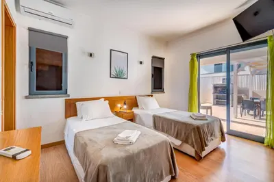 a hotel room with two beds and a balcony at Villa Ruana - 5 bedrooms on Suite- Free out door Hot Jacuzzi - By Bedzy in Albufeira
