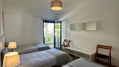 a room with three beds and a window and a chair at Medronheira by Check-in Portugal in Albufeira