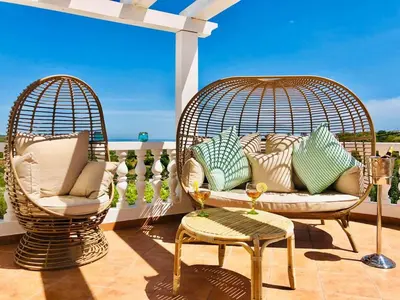 two wicker chairs and a couch on a patio at Luxury Casa da Fonte - Private Heated Salt Pool in Faro