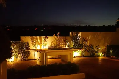 a picnic table in the middle of a patio at night at Luxury Casa da Fonte - Private Heated Salt Pool in Faro