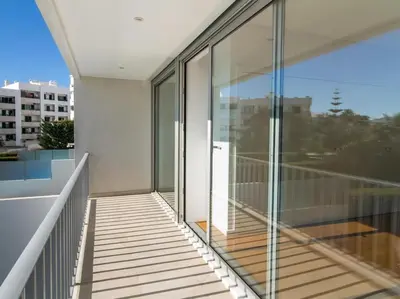 a balcony with glass doors on a building at Harmony 4F House - Privat Heated Pool & Privacy & Albufeira in Albufeira