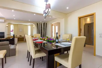 a dining room and living room with a table and chairs at Villa Carlivo in Albufeira