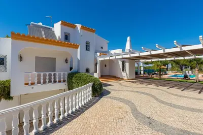 a white house with a white fence and a patio at Villa Carlivo in Albufeira