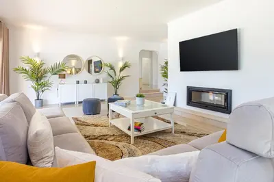 a living room with a white couch and a fireplace at Villa Casinha in Albufeira