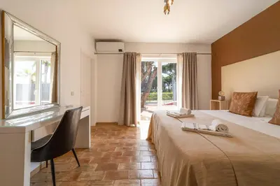 a hotel room with a bed with a desk and a window at Villa Dolce Vita in Albufeira