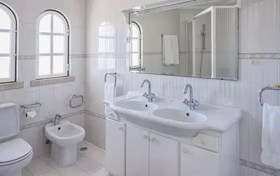 a white bathroom with a sink and a toilet at Villa Solar das Palmeiras in Albufeira