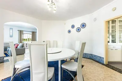 a kitchen and dining room with a white table and chairs at Villa Solar das Palmeiras in Albufeira