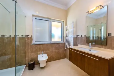 a bathroom with a sink and a toilet and a window at Villa Cor de Rosa in Albufeira