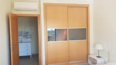 a large wooden closet in a room with a bedroom at Quinta do Pinheiro Residence in Albufeira