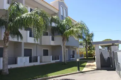 a building with palm trees in front of it at Quinta do Pinheiro Residence in Albufeira