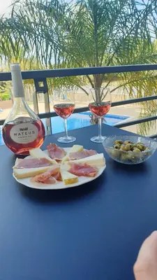 a plate of food and two glasses of wine on a table at Quinta do Pinheiro Residence in Albufeira