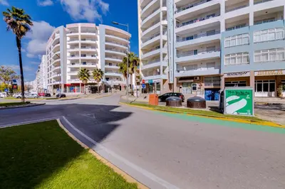 an empty street in front of a large building at Rei - Quarteira - 3 min to the beach in Vilamoura