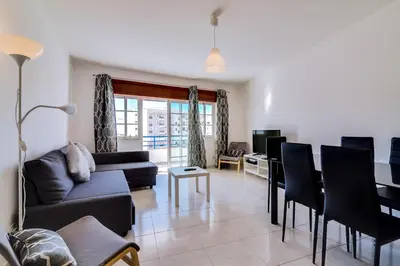 a living room with a couch and a table at Rei - Quarteira - 3 min to the beach in Vilamoura