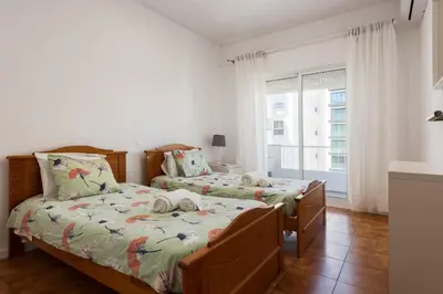 a bedroom with two beds and a window at Maresia - Front beach - Quarteira in Vilamoura