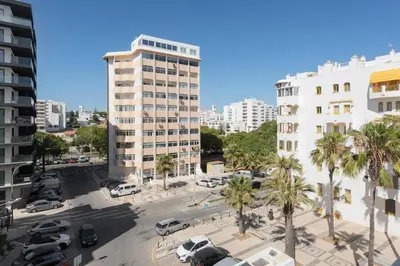 arial view of a parking lot with palm trees and buildings at Maresia - Front beach - Quarteira in Vilamoura