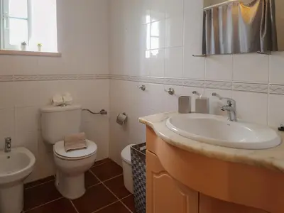 a white bathroom with a toilet and a sink at Falésia Beach Just 800 m (Apartment Surfal) in Roja- Pé