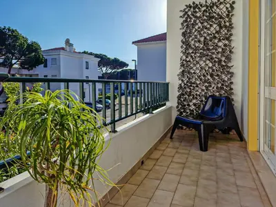 a balcony with a blue chair and a wall at Falésia Beach Just 800 m (Apartment Surfal) in Roja- Pé