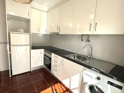 a kitchen with white cabinets and a sink and a washer at Falésia Beach Just 800 m (Apartment Surfal) in Roja- Pé