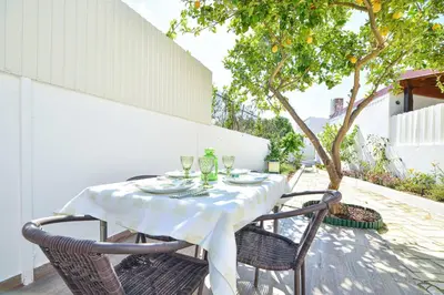 a dining room with a table and a couch at Casa dos Avós by MTPhomes in Albufeira