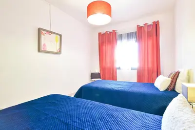a bedroom with a large white bed in a room at Casa dos Avós by MTPhomes in Albufeira