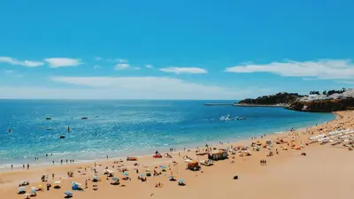 a group of people on a beach with the ocean at Vila Portuguesa by MTPhomes in Albufeira