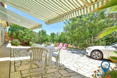 a patio with a table and chairs and a white car at Vila Portuguesa by MTPhomes in Albufeira