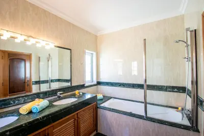a bathroom with two sinks and a shower at Villa Casa Castelo by Algarve Vacation in Albufeira