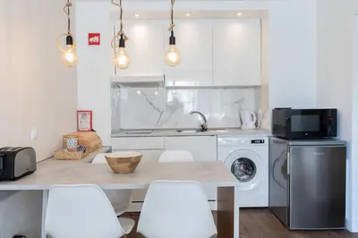 a kitchen with a table and a washing machine at Old Town Apartment 5min to the beach in Albufeira