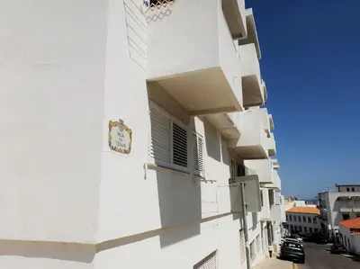 a white building with a clock on the side of it at Old Town Apartment 5min to the beach in Albufeira