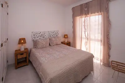 a bedroom with a large bed and a window at Waves by OCvillas in Albufeira
