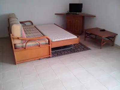 a room with a bed and a table and a tv at Albufeira 1 bedroom apartment 5 min from Falesia beach and close to center D in Albufeira